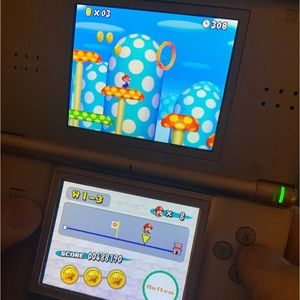 Pink Nintendo DS Lite USG-001 with aftermarket charger & Super Mario Bros game.